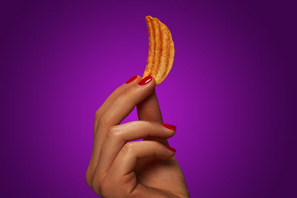 hand holding up a pringles Wavy Crisp